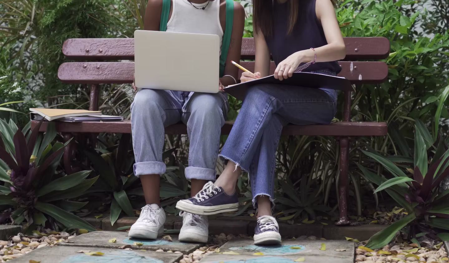 Students sitting together on a bench outdoors